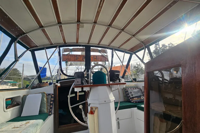 Slide: The Image of 1979 CSY 44 CC sailboat cockpit with wooden accents and steering wheel. - 8