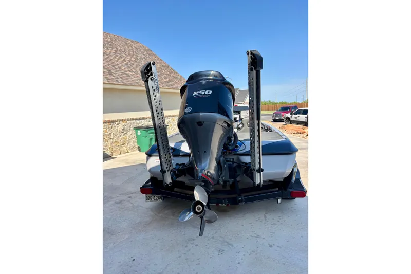 Slide: The Image of 2021 Skeeter FXR21 boat with powerful outboard motor, parked in driveway. - 2