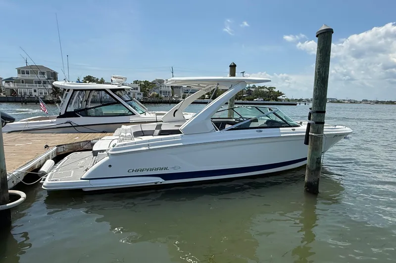 Slide: The Image of 2019 Chaparral 297 SSX boat interior with white seating, docked at marina. - 14