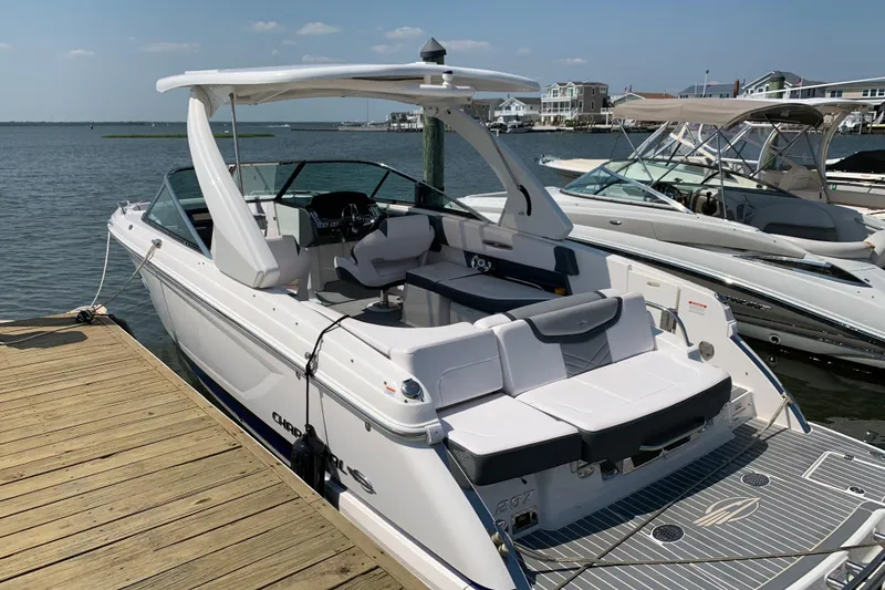 Slide: The Image of 2019 Chaparral 297 SSX boat docked on a sunny day, showcasing sleek design and spacious seating. - 17