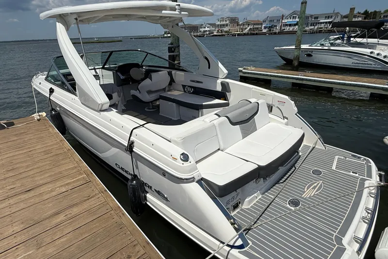 Slide: The Image of 2019 Chaparral 297 SSX boat docked in a marina, clear blue sky background. - 20
