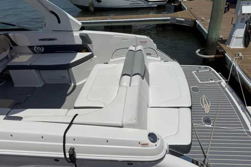 Slide: The Image of 2019 Chaparral 297 SSX boat docked with cover, scenic waterfront view. - 23