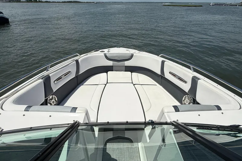 Slide: The Image of 2019 Chaparral 297 SSX boat docked with blue cover, calm waters in the background. - 27