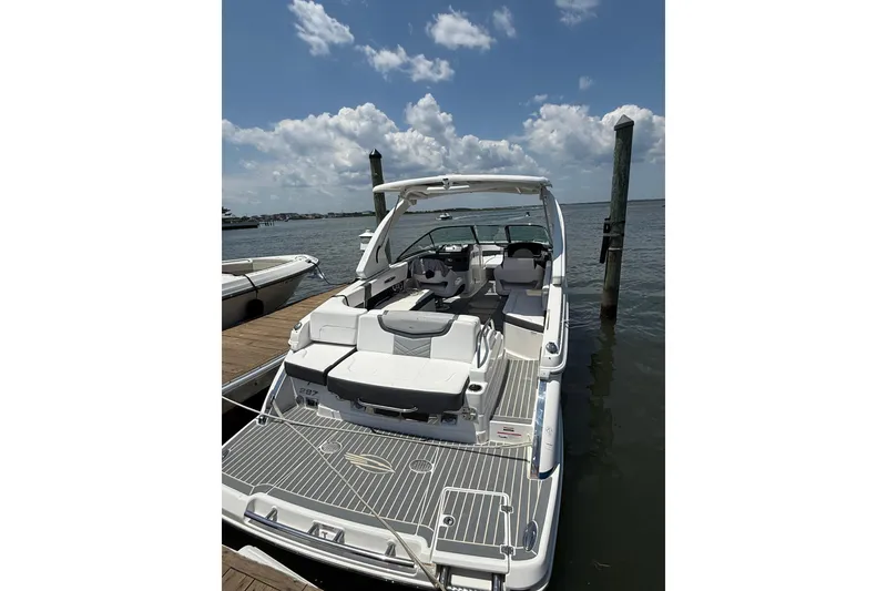 Slide: The Image of 2019 Chaparral 297 SSX boat with blue cover docked at marina. - 28