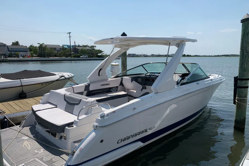 Slide: The Image of 2019 Chaparral 297 SSX boat docked by the water on a sunny day. - 4