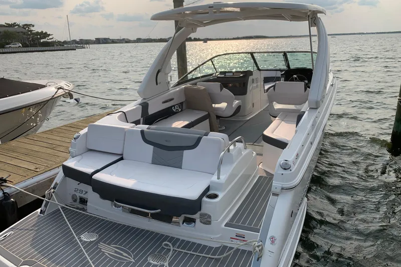 Slide: The Image of 2019 Chaparral 297 SSX boat docked by the water, showcasing spacious seating and sleek design. - 5