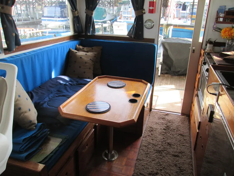 Slide: The Image of Interior of a 1966 Grand Banks 32 Sedan with wooden table and blue cushions. - 15