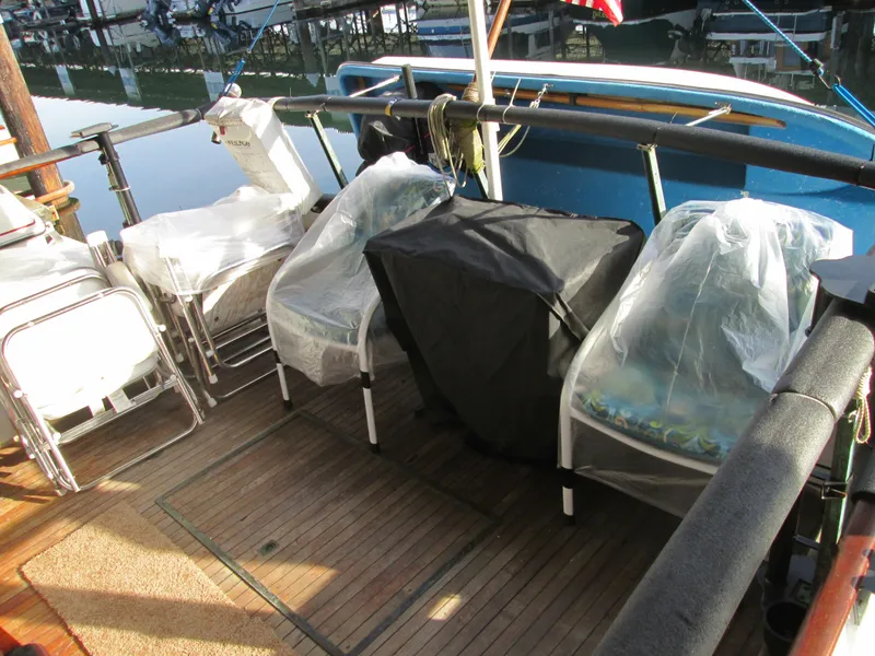 Slide: The Image of Deck of a 1966 Grand Banks 32 Sedan with chairs and covers. - 4