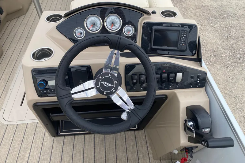 Slide: The Image of 2026 SunCatcher Select 322RC boat dashboard with steering wheel, gauges, and controls. - 11