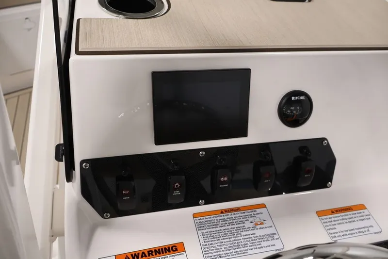 Slide: The Image of Control panel of 2026 Yamaha Boats 195 FSH Sport with switches and compass. - 29