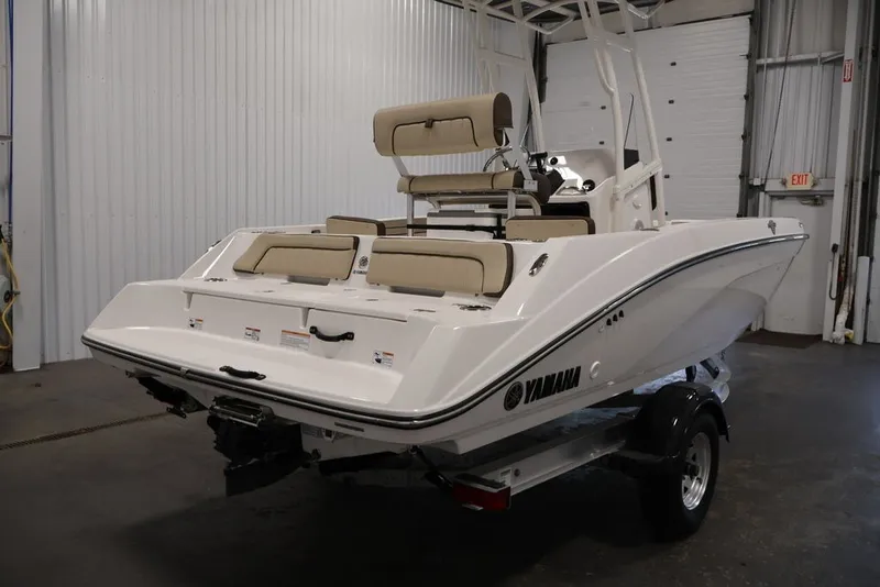 Slide: The Image of 2026 Yamaha Boats 195 FSH Sport in a garage, showcasing sleek design and seating. - 5