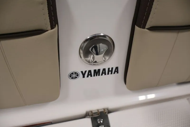 Slide: The Image of 2026 Yamaha Boats 195 FSH Sport interior detail with logo and beige upholstery. - 24