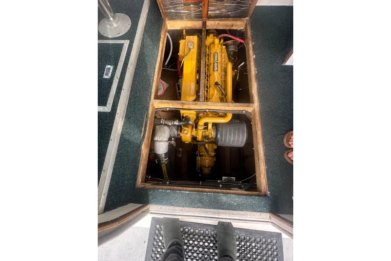 Slide: The Image of Engine compartment of a 1999 Samson East Coast Lobster boat, showcasing a yellow engine. - 19