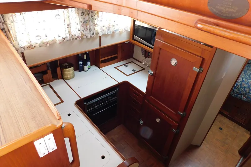 Slide: The Image of 1986 Grand Banks 46 Classic yacht kitchen with wood cabinetry and modern appliances. - 11