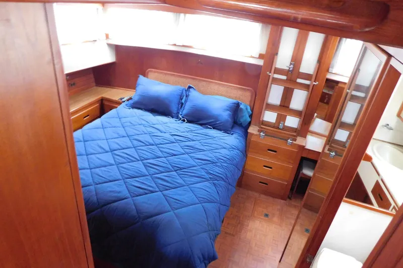 Slide: The Image of Cozy bedroom in 1986 Grand Banks 46 Classic yacht with blue bedding and wooden cabinetry. - 13