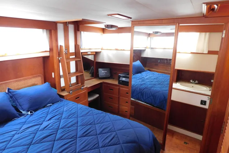 Slide: The Image of Interior of 1986 Grand Banks 46 Classic yacht with blue bedding and wooden furnishings. - 15