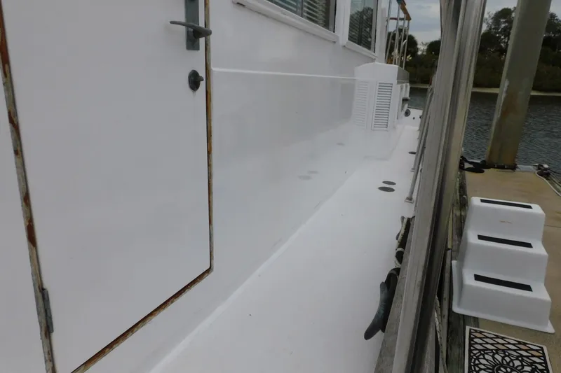 Slide: The Image of Side view of 1986 Grand Banks 46 Classic yacht docked by the water. - 19