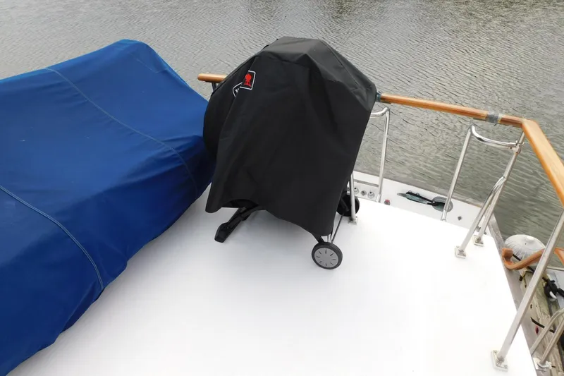Slide: The Image of 1986 Grand Banks 46 Classic yacht deck with covered grill and blue tarp. - 21
