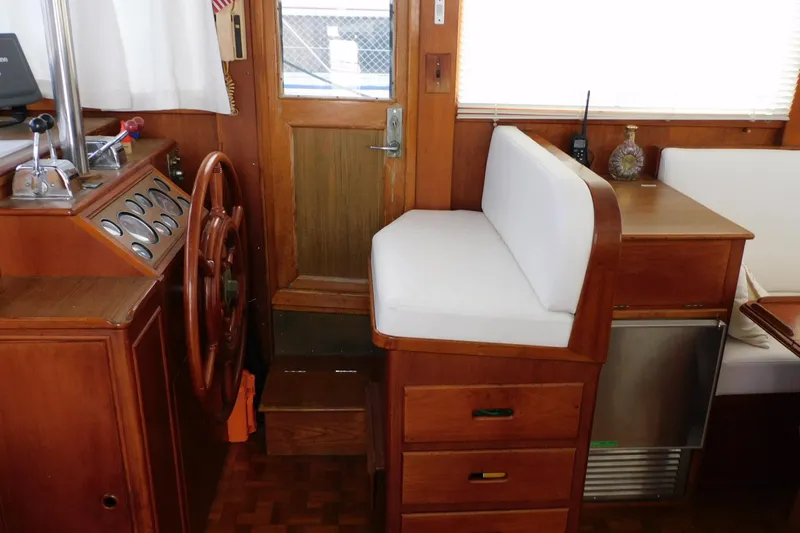 Slide: The Image of Interior helm of 1986 Grand Banks 46 Classic yacht with wooden steering wheel and seating. - 4