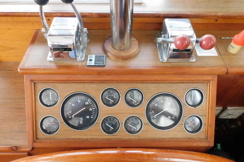 Slide: The Image of Control panel of a 1986 Grand Banks 46 Classic yacht with gauges and throttle levers. - 5