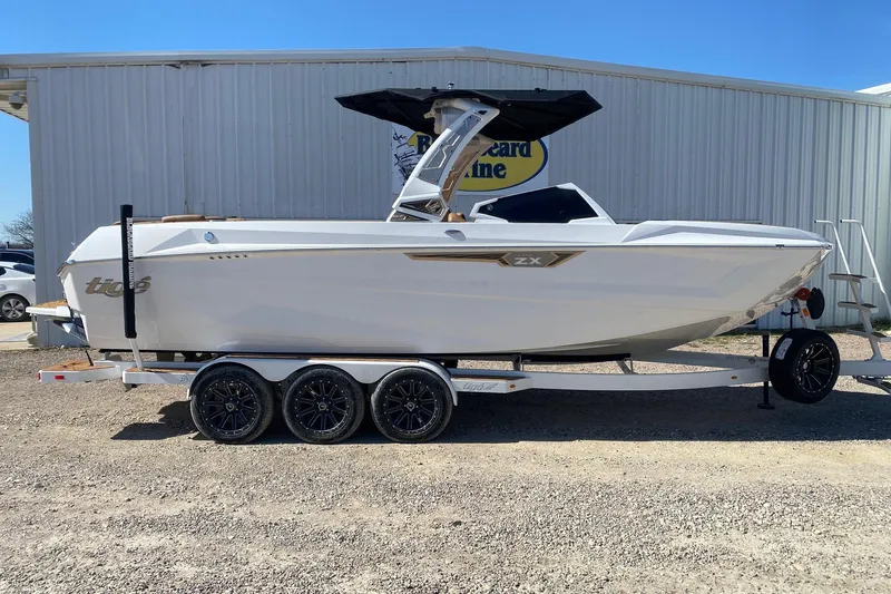 The Image of 2025 Tigé Ultré 25ZX boat on trailer, parked outdoors, side view. - 1