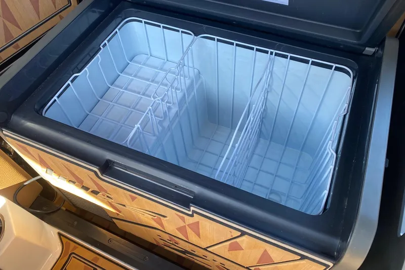 Slide: The Image of Open storage compartment in 2025 Tigé Ultré 25ZX boat, featuring organized interior space. - 9