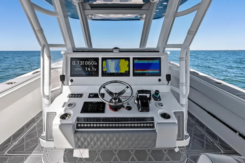Slide: The Image of 2024 Invincible 46 Catamaran helm with advanced navigation displays on open water. - 18
