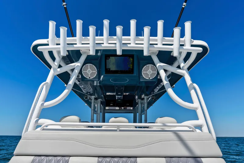 Slide: The Image of 2024 Invincible 46 Catamaran helm with rod holders and speakers under clear blue sky. - 26