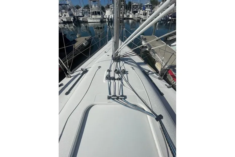 Slide: The Image of Deck view of a 1997 Beneteau 25 Platu sailboat docked in a marina. - 6