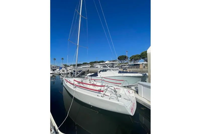 Slide: The Image of 1997 Beneteau 25 Platu sailboat docked in marina under clear blue sky. - 7