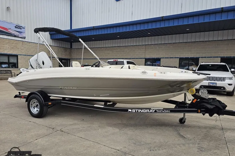 Slide: The Image of 2022 Stingray 182 SC boat on trailer, parked outside a building. - 10