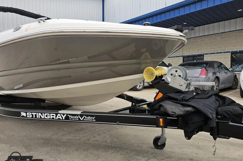 Slide: The Image of 2022 Stingray 182 SC boat on trailer, parked outside a building. - 12
