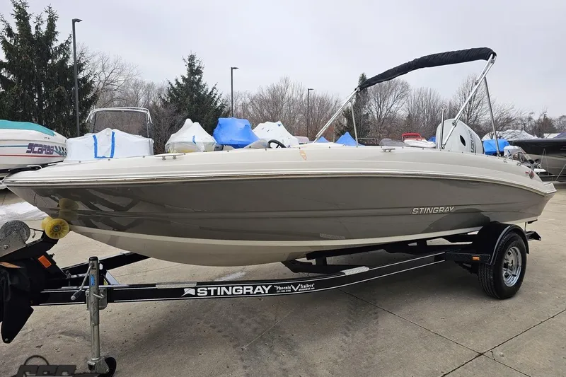 Slide: The Image of 2022 Stingray 182 SC boat on trailer, parked outdoors with protective covers nearby. - 17