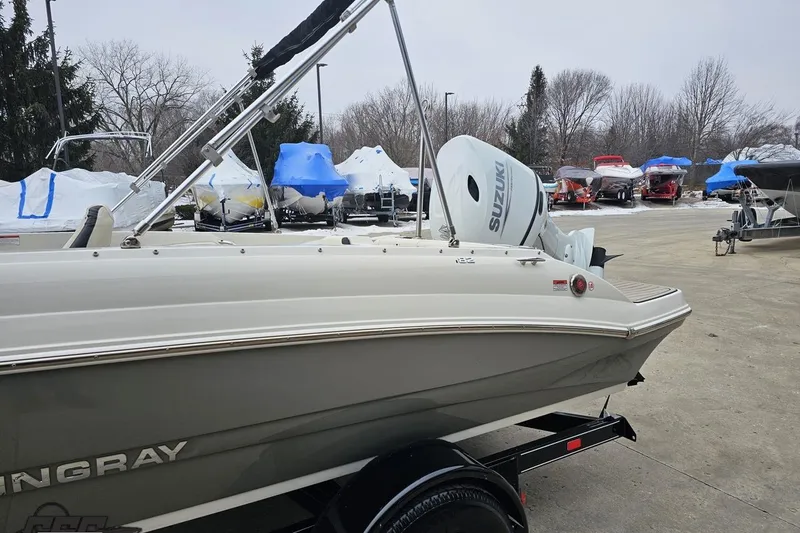 Slide: The Image of 2022 Stingray 182 SC boat with Suzuki outboard motor in a marina setting. - 20