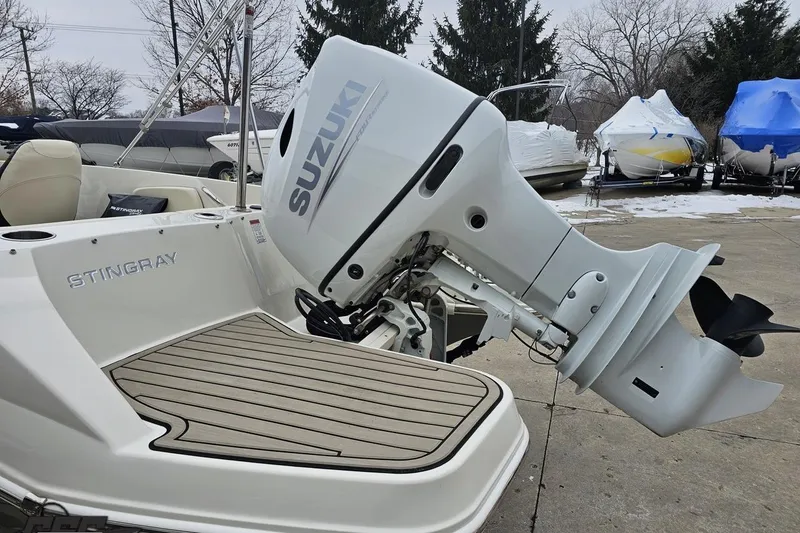Slide: The Image of 2022 Stingray 182 SC boat with Suzuki outboard motor, docked on a snowy day. - 25