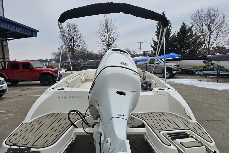 Slide: The Image of 2022 Stingray 182 SC boat with outboard motor, parked outdoors on a snowy day. - 28