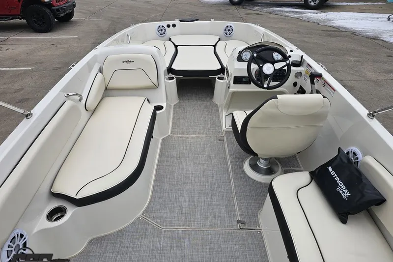 Slide: The Image of 2022 Stingray 182 SC boat interior with white seating and steering wheel. - 36