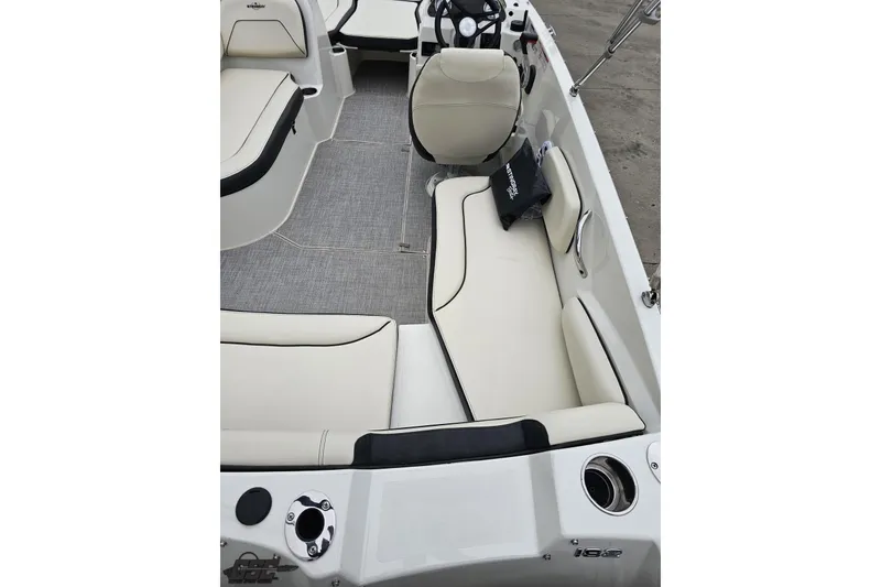 Slide: The Image of 2022 Stingray 182 SC boat interior with white seating and steering wheel. - 37