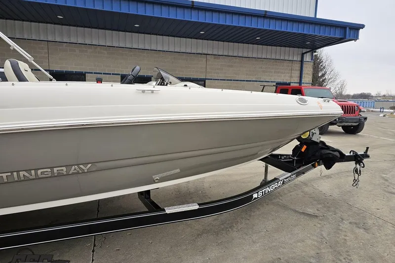 Slide: The Image of 2022 Stingray 182 SC boat on trailer, parked outside a building. - 4