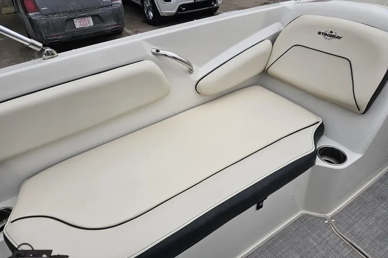 Slide: The Image of 2022 Stingray 182 SC boat interior with cream and black seating, cup holder, and sleek design. - 43