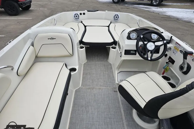 Slide: The Image of 2022 Stingray 182 SC boat interior with white seating and modern dashboard. - 47