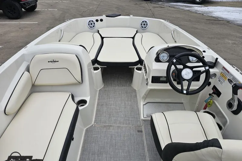 Slide: The Image of 2022 Stingray 182 SC boat interior with white seating and modern dashboard. - 48