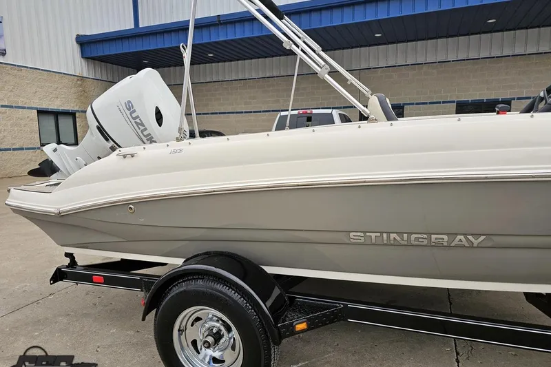 Slide: The Image of 2022 Stingray 182 SC boat with Suzuki engine on trailer, parked outside a building. - 5