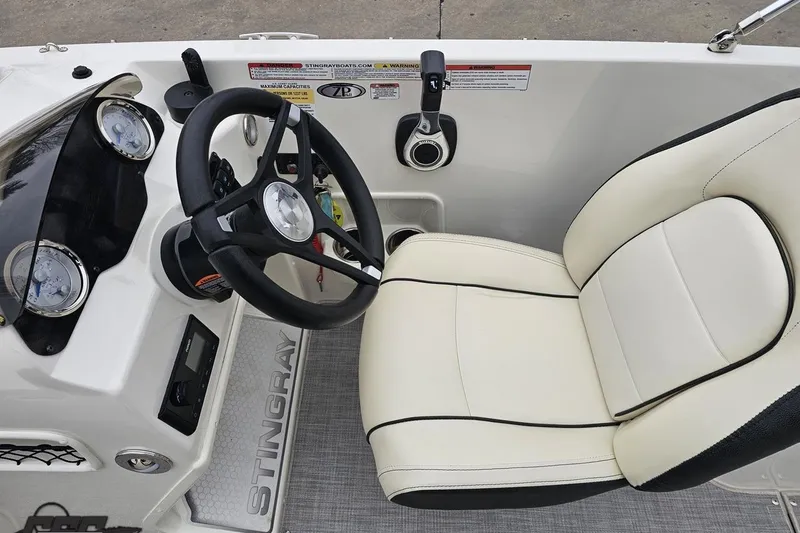Slide: The Image of 2022 Stingray 182 SC boat cockpit with steering wheel and comfortable seating. - 53