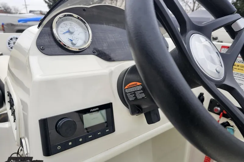 Slide: The Image of 2022 Stingray 182 SC boat dashboard with steering wheel and control panel. - 54