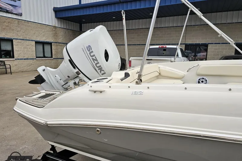 Slide: The Image of 2022 Stingray 182 SC boat with Suzuki outboard motor, parked outdoors. - 6