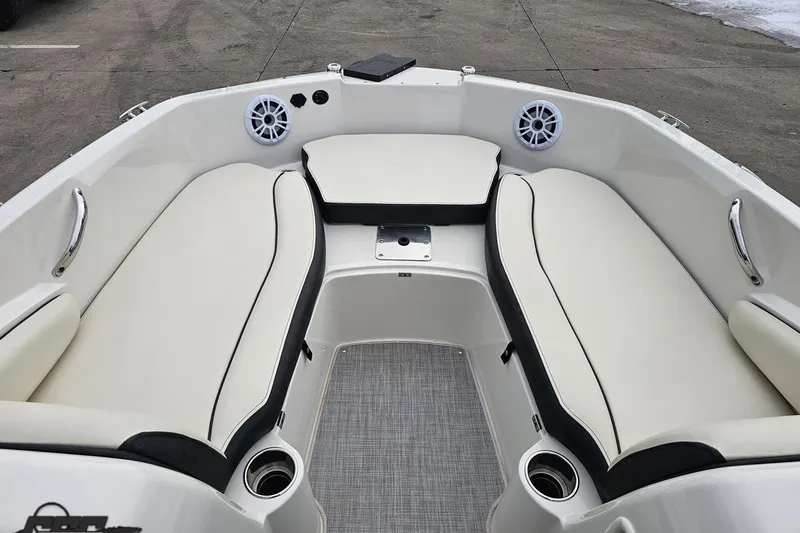 Slide: The Image of 2022 Stingray 182 SC boat interior with white cushioned seating and speakers. - 67