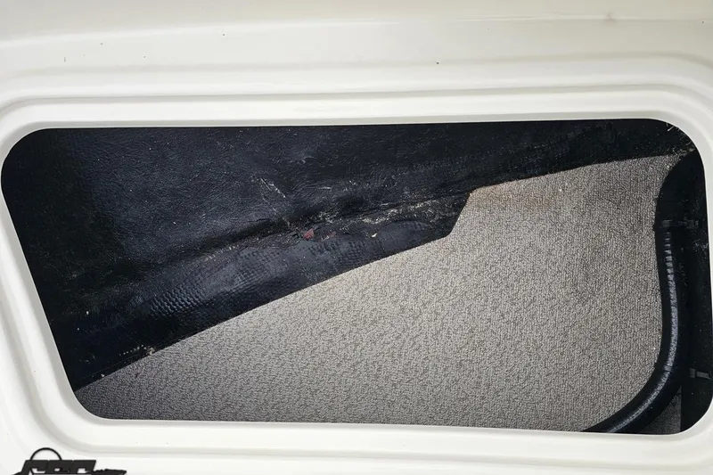 Slide: The Image of Storage compartment interior of 2022 Stingray 182 SC boat, featuring black and beige surfaces. - 68