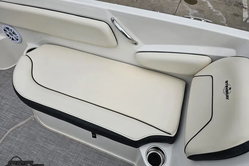Slide: The Image of 2022 Stingray 182 SC boat interior with white cushioned seating and logo. - 77