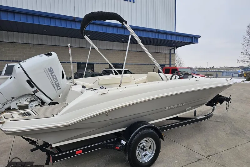 Slide: The Image of 2022 Stingray 182 SC boat with Suzuki engine on trailer, parked outdoors. - 8